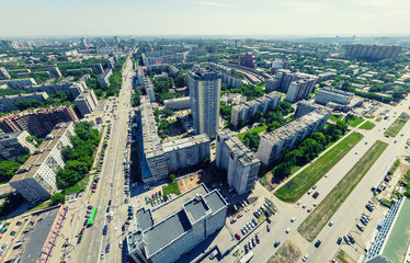 Naklejka na ściany i meble Aerial city view with crossroads and roads, houses, buildings, parks and parking lots, bridges. Urban landscape. Copter shot. Panoramic image.