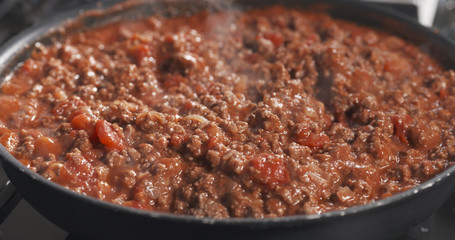 roasting minced beef with tomato paste in a pan
