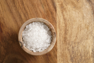 Fototapeta na wymiar coarse sea salt in wooden bowl on table
