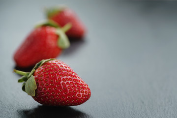 ripe organic strawberries on slate background