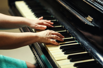 Obraz premium Beautiful woman playing piano,Close up of woman hands playing piano,Favorite classical music. Top view with dark vignette.