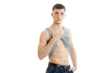 young sexy guy with a nice torso raises hand their shirt and looking at camera