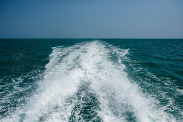 Water splash behind of speed boat at dark ocean