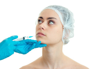 Portrait of a young girl in the medical CAP which the beautician enters the vaccine close-up