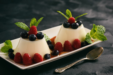 Italian dessert - panna cotta with berries and caramel sauce.