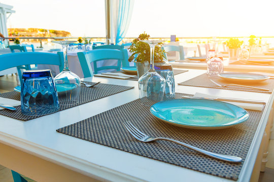 traditional tavern on the island of Crete Greece. The tables are served dishes and glasses on the beach. Hersonissos