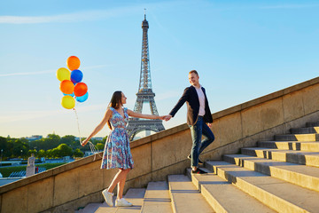 Romantic couple with colorful balloons near the Eiffel tower