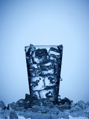 isolated glass of water with ice cubes on a light blue background