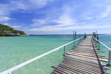 Fototapeta premium Wood bridge pier on summer tropical sea in blue sky.