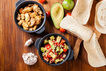 Ingredients ready for preparing chicken tacos with salsa made fr
