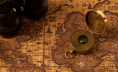 Old vintage retro compass on ancient world map. Vintage still life. Travel geography navigation concept background.