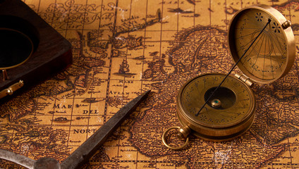 Fototapeta na wymiar Old vintage retro compass on ancient world map. Vintage still life. Travel geography navigation concept background.