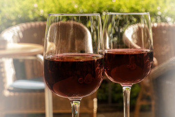Two glasses of red wine on a sunlit terrace
