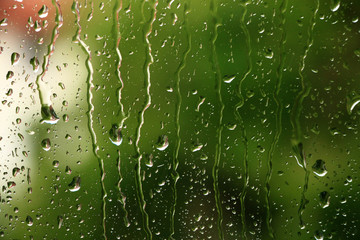 Rain drops on window with green in background