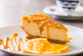 piece of cheesecake served on a white plate with a cup of coffee