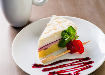 piece of cheesecake served on a white plate with a cup of coffee