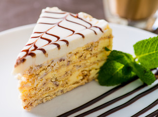 piece of cake served on a white plate with a cup of coffee