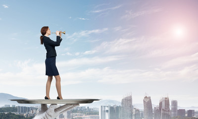 Attractive businesswoman on metal tray playing fife against cityscape background
