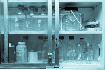 Laboratory glassware or beakers in cold and vintage tone stack on shelf, science research,science concept