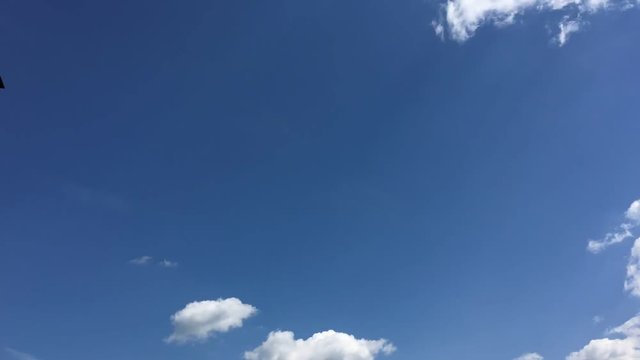 Clouds running across the blue sky. Timelapse cloudscape. Cumulus clouds form against a brilliant blue sky. Timelapse of white clouds with blue sky in background 