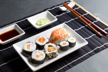 Japońskie sushi w rolkach na czarnej bambusowej macie