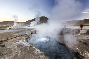 Fototapeta na wymiar geyser tatio with water surface at sunrise