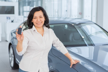 Attractive woman customer choosing a car at the dealership