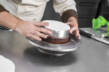 Obraz na płótnie Canvas preparazione di una torta al cioccolato in una pasticceria artigianale