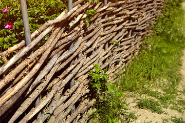 Fototapeta na wymiar wicker rustic fence in the garden