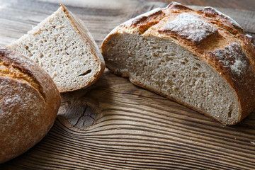 A freshly baked rustic, loaf of bread on an old wooden table