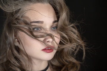 luxury woman with flying long hair on black background