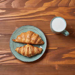 food plate of breakfast with croissant and glass of milk