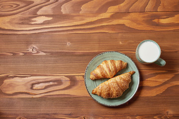 food plate of breakfast with croissant and glass of milk