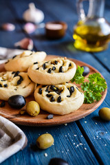 Baked bread rolls filled with chopped olives and garlic