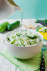  vegetarian Healthy food, light, low calorie fitness salad of fresh cucumbers, cabbage and dill with olive or sunflower oil, spices and salt on a light wooden background 