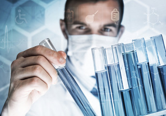 Portrait of concentrated male scientist working with reagents in laboratory