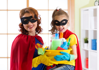 Mother and her child in Superhero costume. Mum and kid ready to house cleaning. Houseworking and housekeeping.