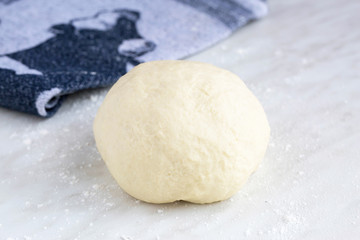 Homemade dough for german flammkuchen or french tarte flambé. On white table. Natural light, selective focus. 