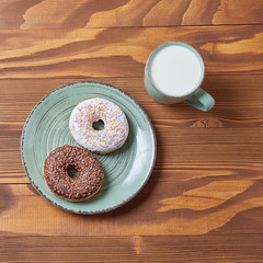 food plate of donut and croissant with mug of coffe on wooden background