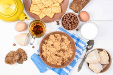 Top view of healthy breakfast. Oat cereal granola in bowl on white wooden background