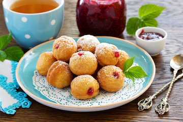 Donuts filled with raspberry jam and powdered sugar in.