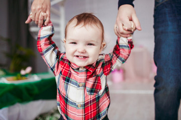 Smiling girl holds parents' hands