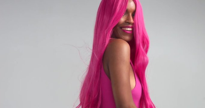 Black women dancing in pink wig