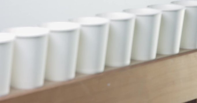 row of white blanc paper cups goes to unfocus