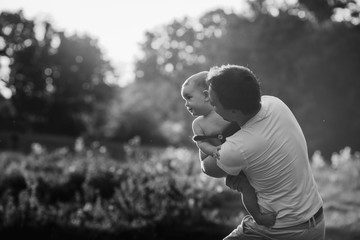 Little daughter looks over father's shoulder while he holds her in his arms