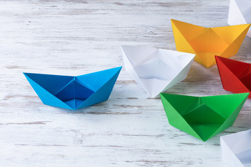 Business leadership concept with white and color paper boats on 