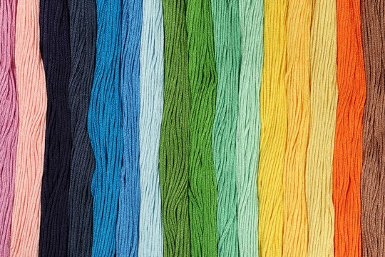 Multicolored cotton threads for embroidery are arranged in a row