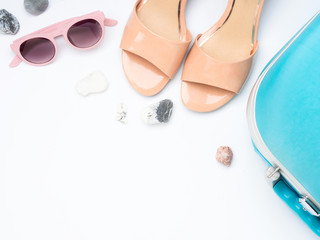 Fototapeta na wymiar Blue suitcase, sandals, sun glasses and stones. Packing for sea destination. Travel concept