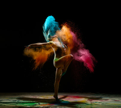 Girl dancing in a cloud of color dust studio portrait