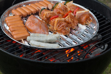 Fleisch und Gemüse auf Kugelgrill, glühende Kohle, Grillsaison